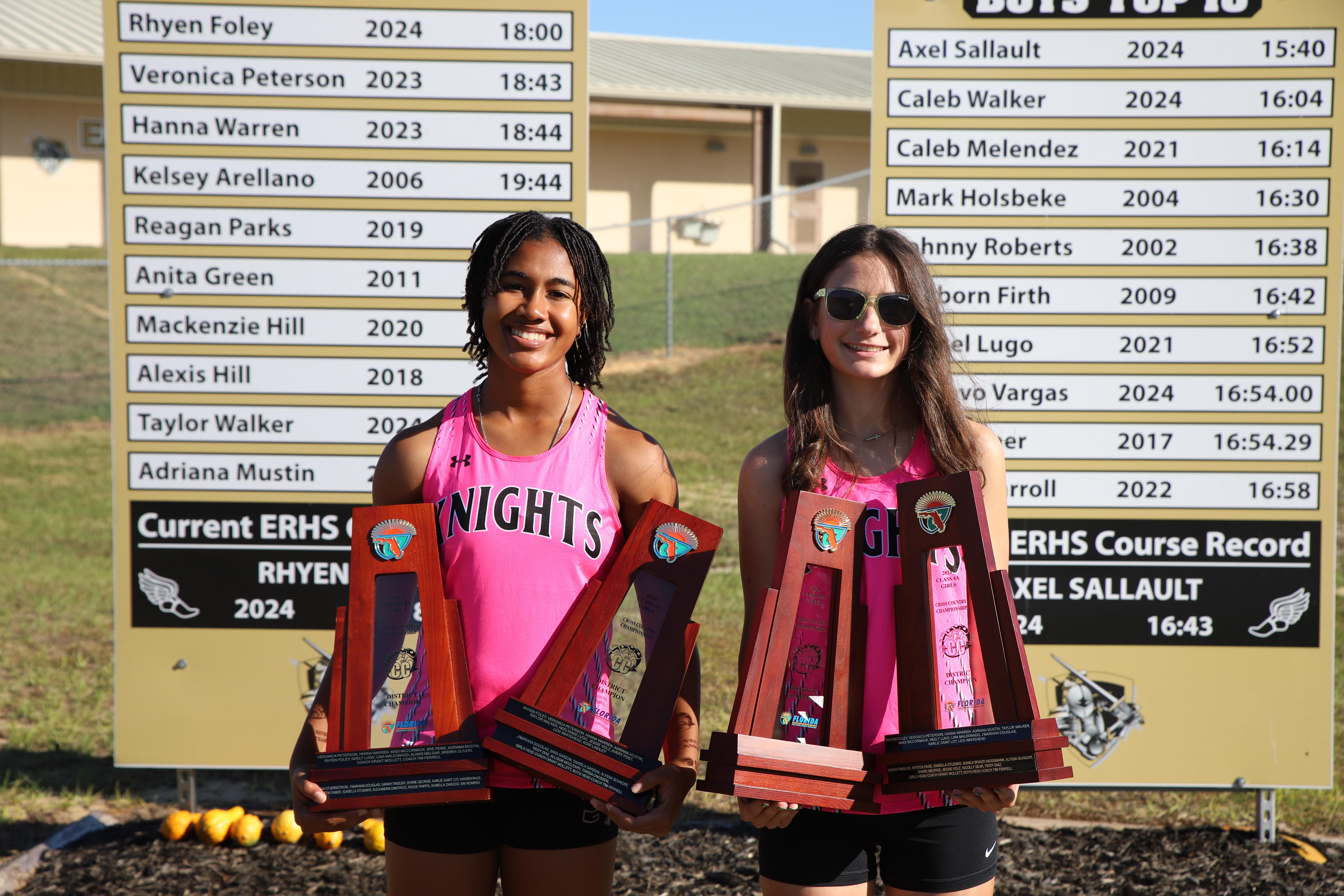 Seniors Veronica Peterson and Rhyen Foley pose with the 2022, 2023, 2024, and 2025 district championship trophies