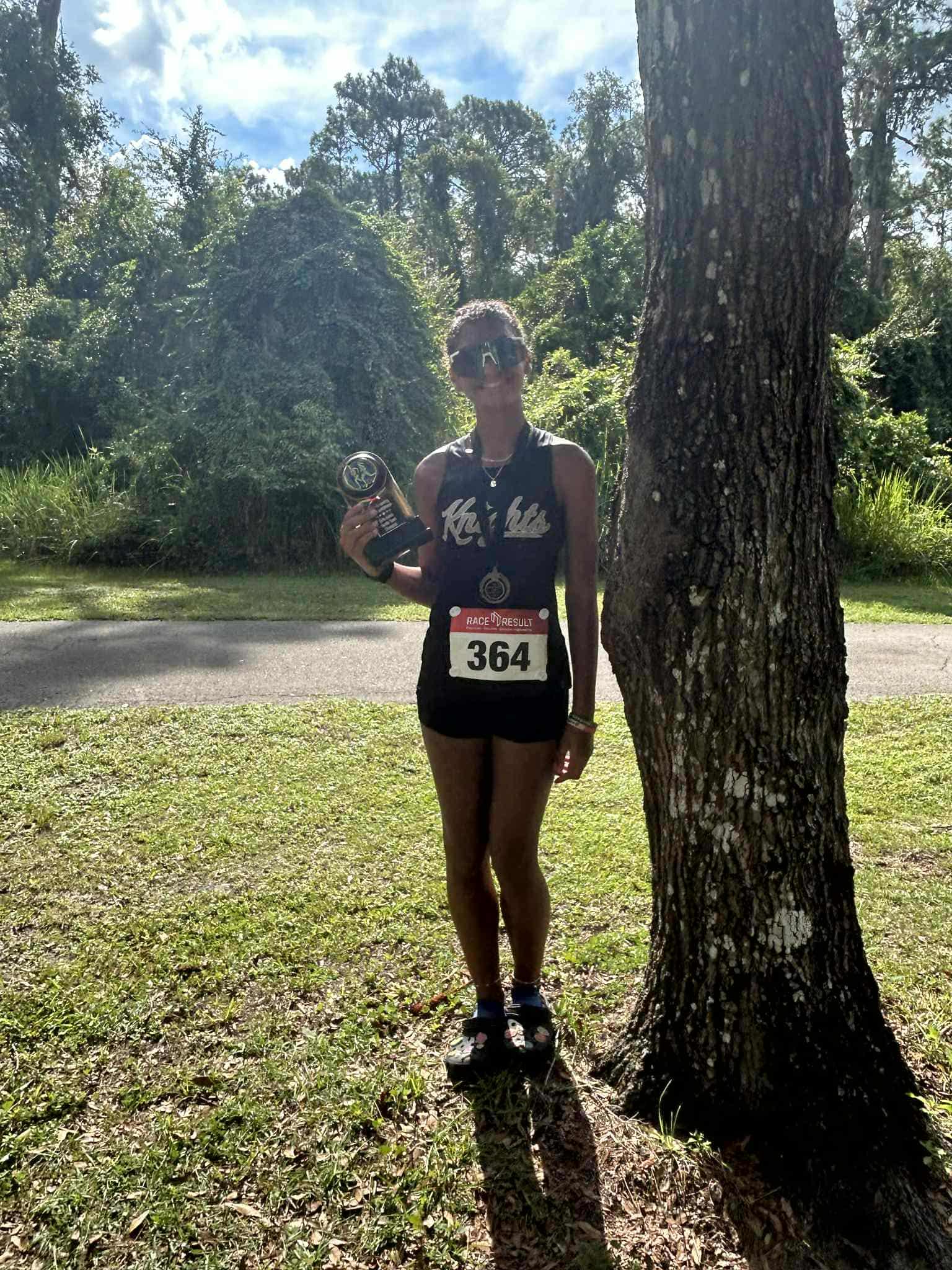 Sophomore Helen Robertson poses with her individual championship she won in the junior varsity race at Whispering Pines earlier this season