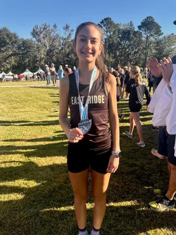 Rhyen showing off her fourth place medal after the 2024 Class 4A Cross Country State Championships